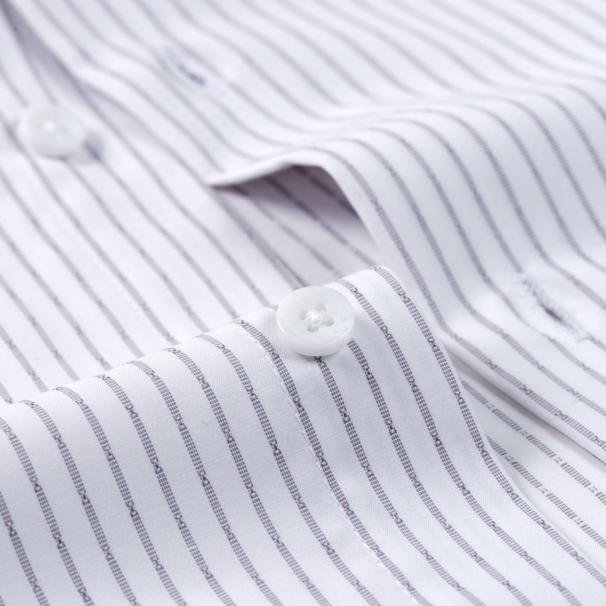 Close-up of the FAHIZO Mens Dress Shirt Regular Fit Casual Long Sleeve with thin gray stripes, two white buttons, collar, and placket visible. The stretch fabric looks smooth, breathable, durable, and neatly pressed.